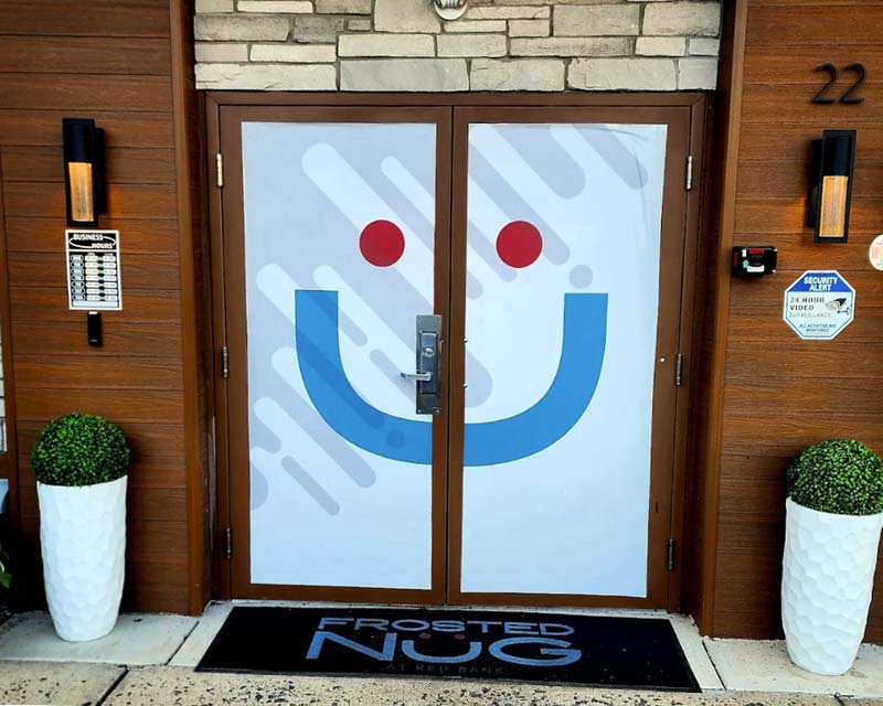 Entrance to One of Frosted Nug New Jersey Dispensaries with Smiling Face Icon on Front Door